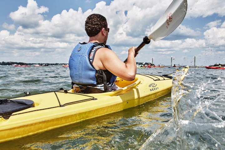 a man riding on the back of a boat in a body of water