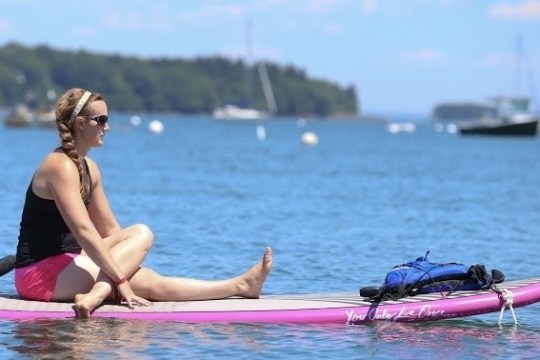 a woman sitting on a boat in a body of water